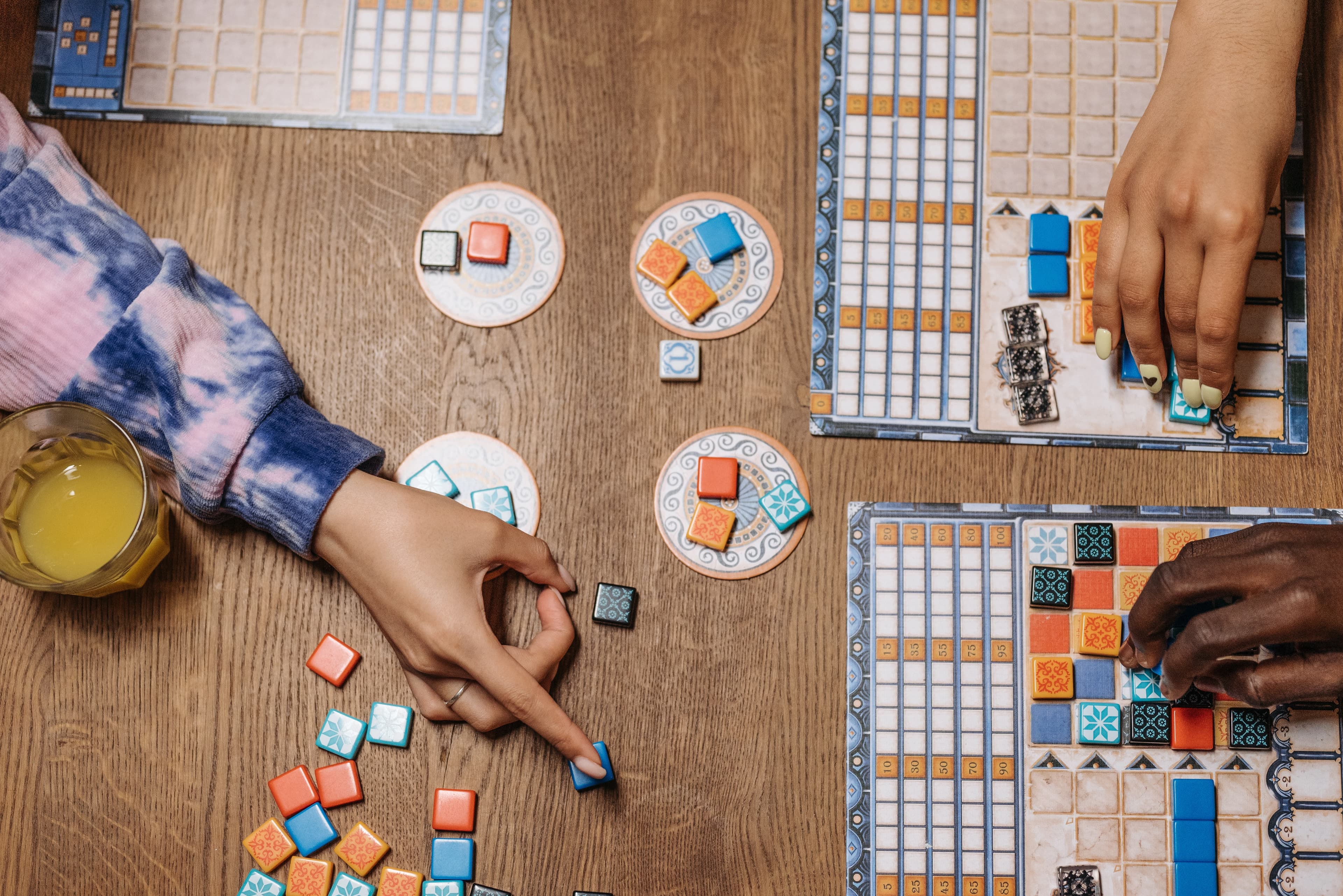 People playing the game Azul at a table, photo by Pavel Danilyuk